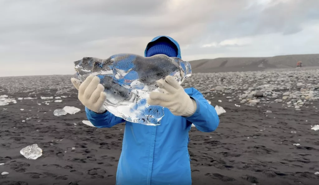 Catu holding up a pieace of ice from the diamond beach